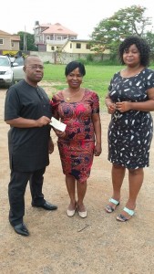 Monday Ubani giving  Josephine Ugwu the cheque